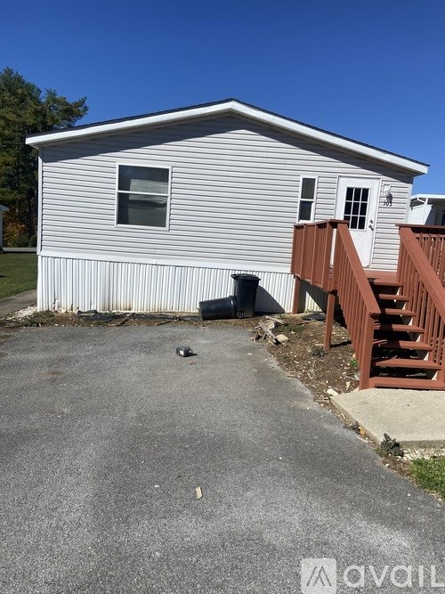 A house with a grey siding and a brown deck.