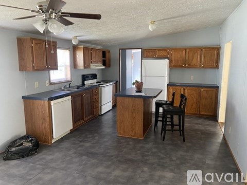 A kitchen with wooden cabinets and a black chair.