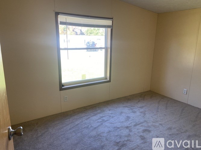 A room with a window and a car parked outside.