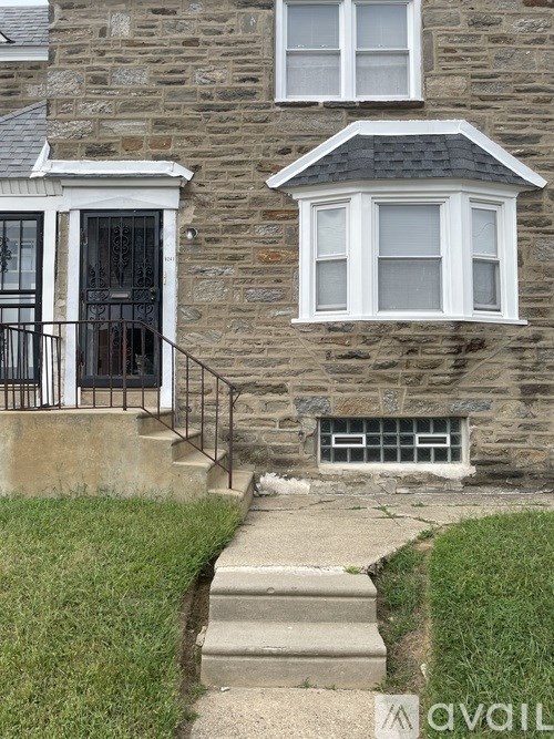 A stone house with a black iron railing.