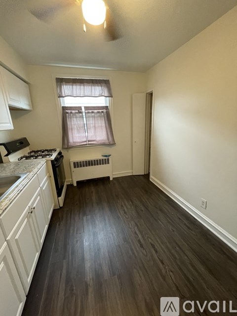 A kitchen with white cabinets and a black stove top oven.