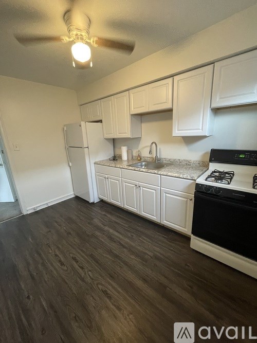 A kitchen with white cabinets and a black stove top oven.