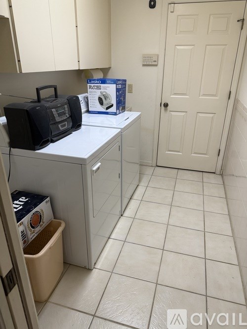 A small kitchen with a white fridge and a black radio on the counter.