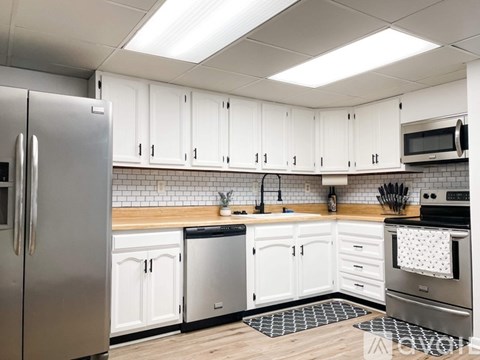 A kitchen with white cabinets and stainless steel appliances.