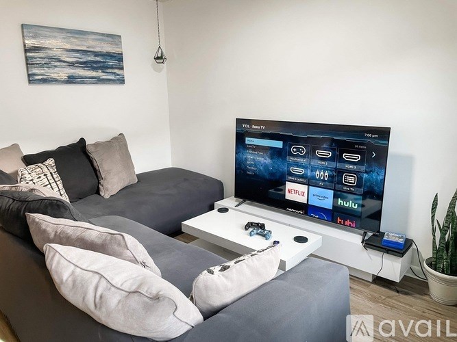 A modern living room with a large TV displaying streaming services.