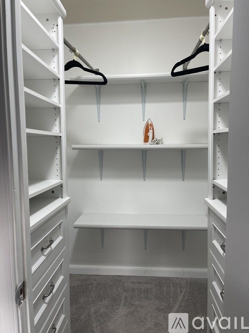 A white closet with a bench and hangers.