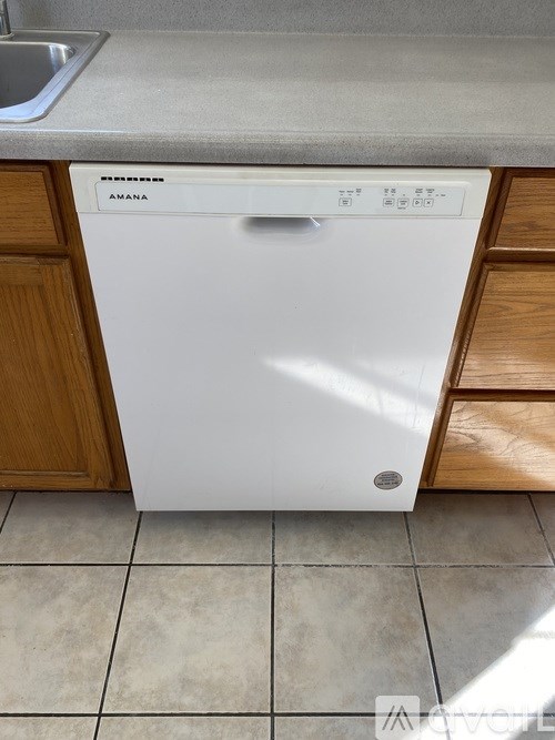 A white Amana dishwasher is sitting in a kitchen.