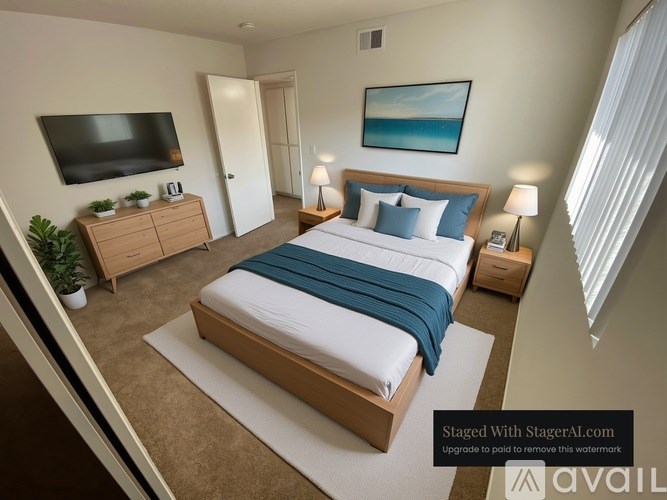 A bedroom with a large bed and a flat screen TV mounted on the wall.