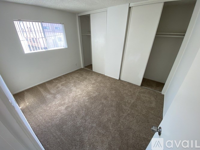 A room with a carpeted floor and a window.