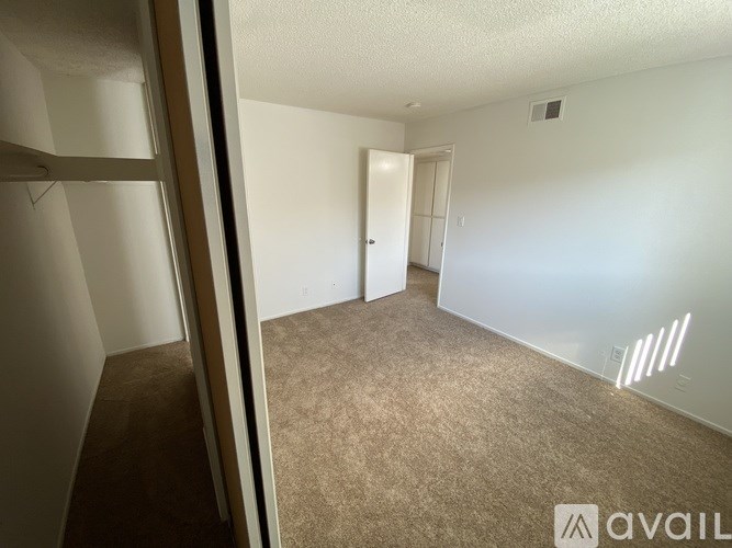 A room with carpeted floor and a door visible in the background.