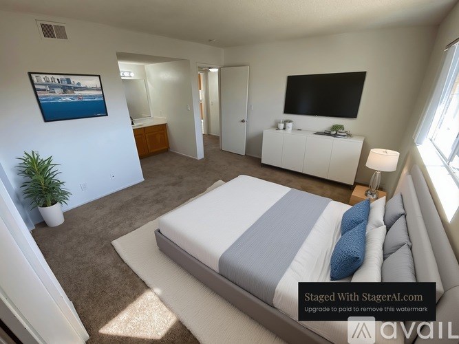 A bedroom with a bed, a television, and a plant.