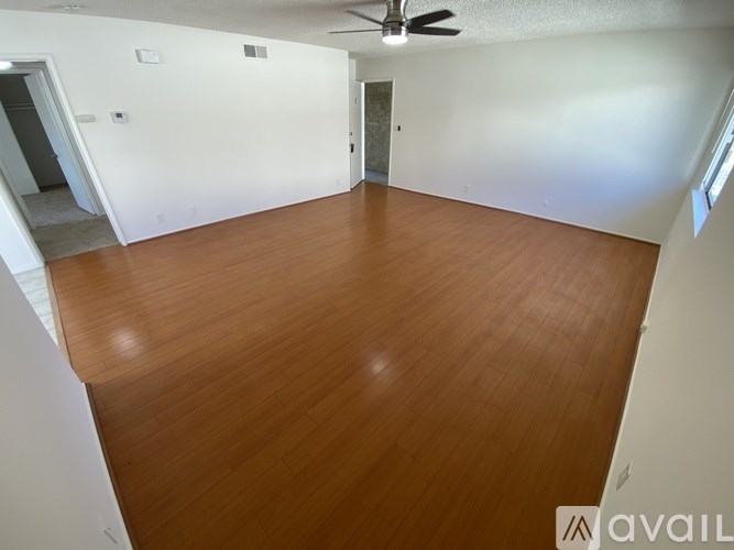 A room with wooden flooring and a ceiling fan.