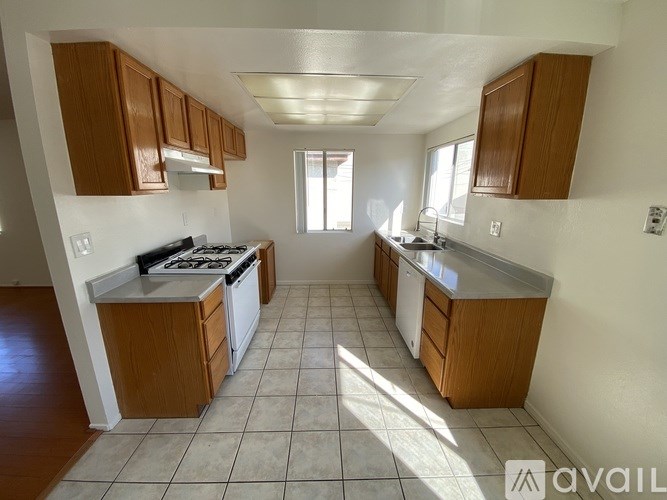 A kitchen with wooden cabinets and a white stove top oven.