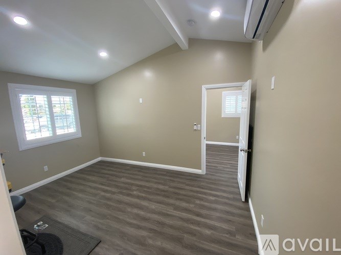 A room with a door, window, and a mat on the floor.