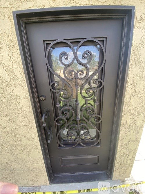 A black door with a decorative metal grill.