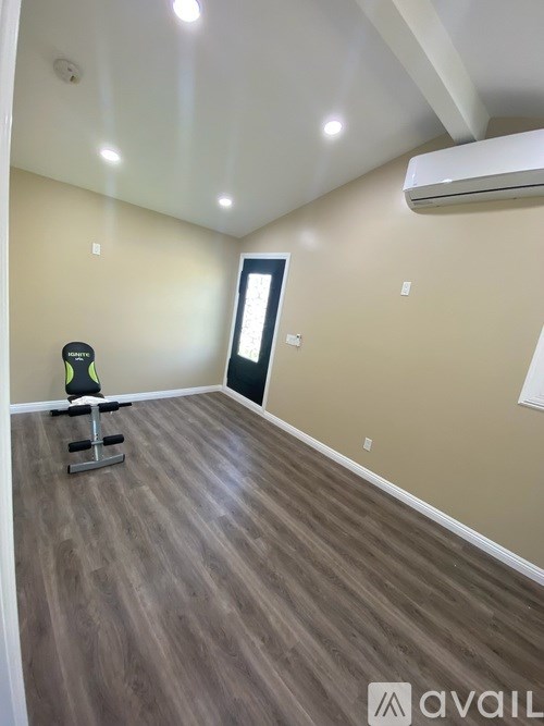 A room with a wooden floor and a black chair.