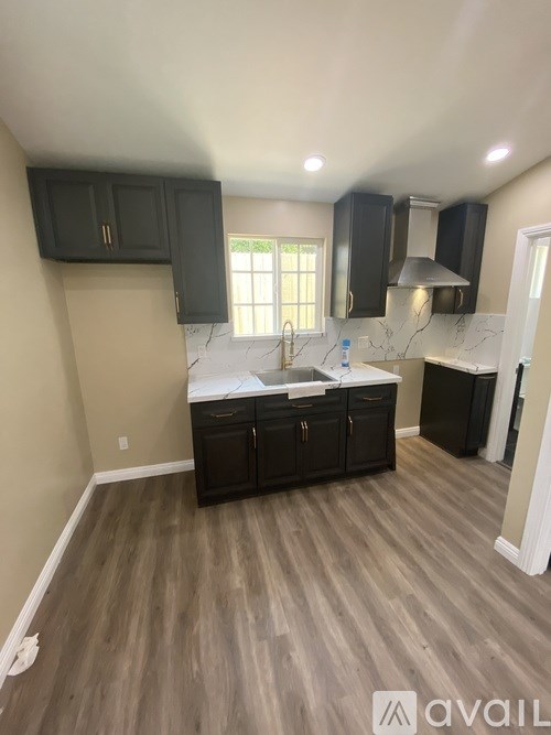 A kitchen with dark wood cabinets and a white countertop.