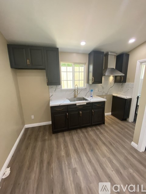 A kitchen with dark wood cabinets and a white countertop.