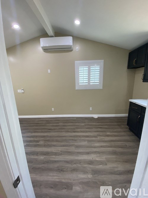 A room with a window, a door, and a wall-mounted air conditioner.