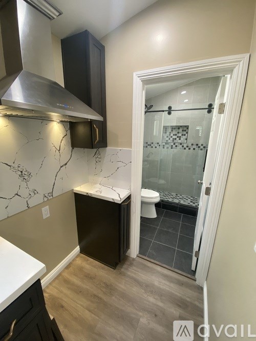 A bathroom with a marble counter top and a walk-in shower.