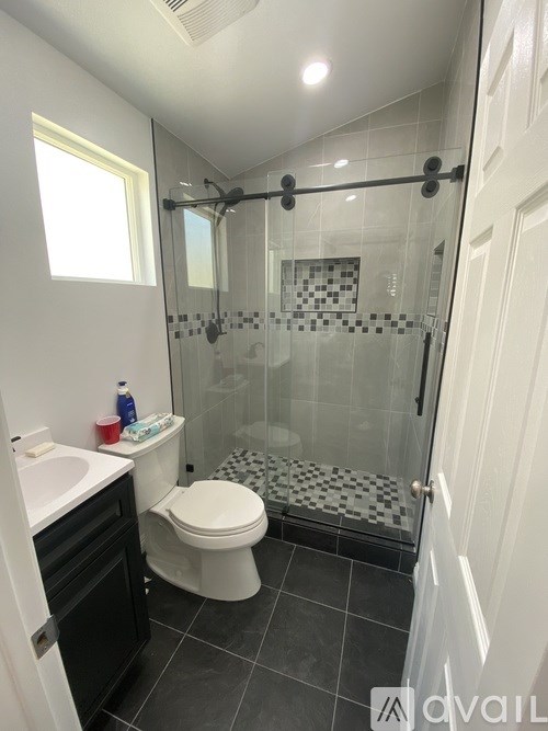 A bathroom with a toilet, sink, and shower.