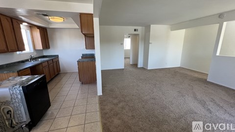 A kitchen with brown cabinets and a black refrigerator.