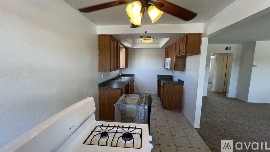 A kitchen with a white stove top and wooden cabinets.