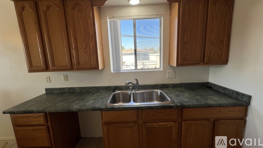 A kitchen with wooden cabinets and a granite countertop.