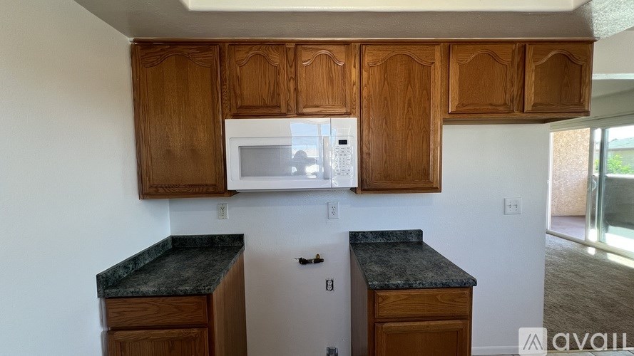A kitchen with wooden cabinets and granite countertops.