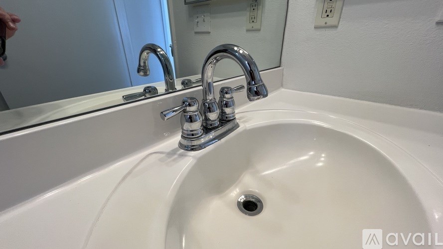 A white sink with a chrome faucet in a bathroom.
