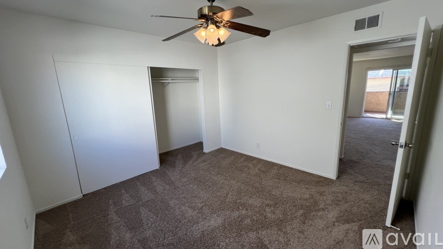 A room with a ceiling fan and carpeted floor.