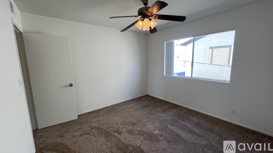 A room with a ceiling fan and carpeted floor.
