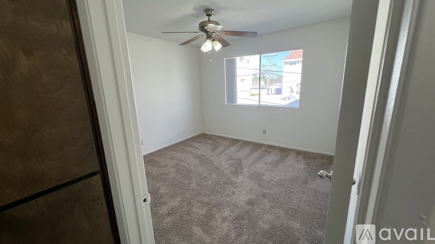 A room with a ceiling fan and a window.