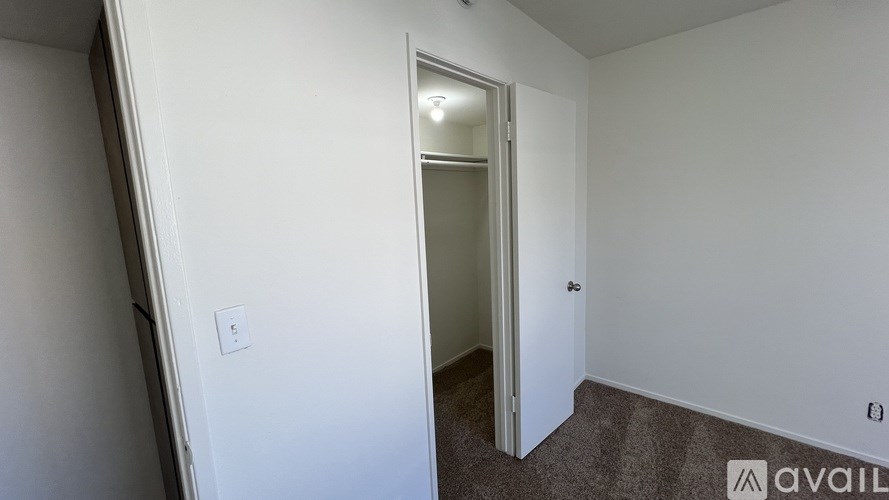 A room with a carpeted floor and a doorway leading to another room.