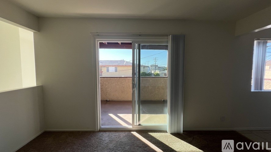 A room with a large open door leading to a balcony.