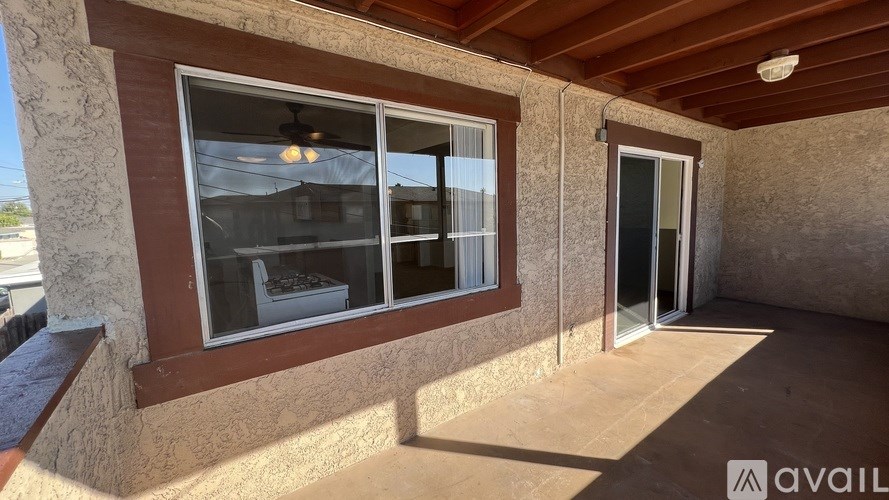 A patio area with a table and chairs and a window.