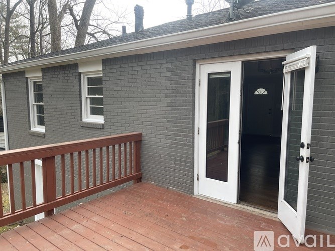 A small house with a white door and a red deck.