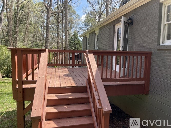 A wooden deck with stairs leading to a house.