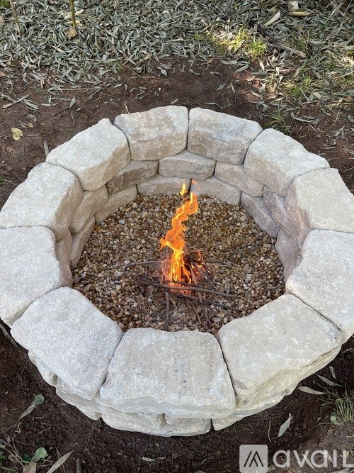 A fire burns in a stone fire pit.