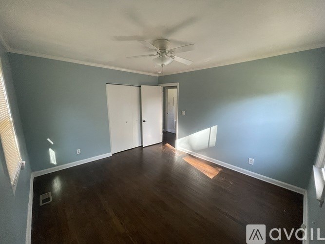 A room with a ceiling fan and a door.