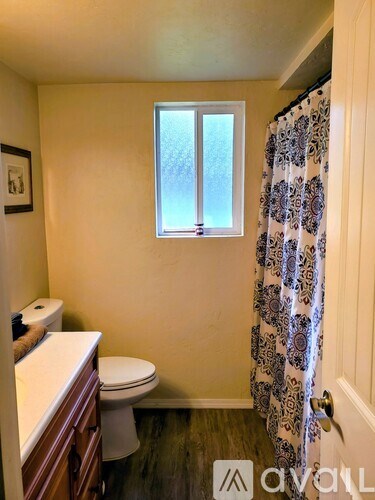 A small bathroom with a toilet, sink, and a window.