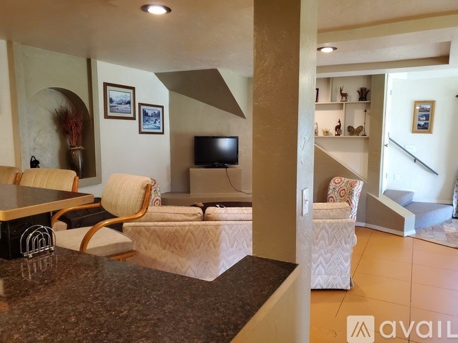 A living room with a couch, chair, and television.
