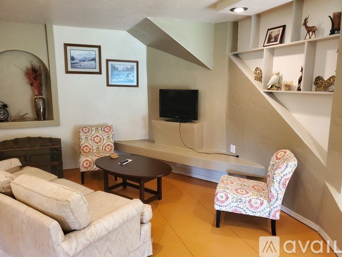 A living room with a couch, chair, and television.