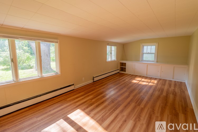 A room with wooden floors and large windows.
