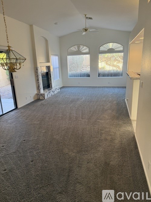 A spacious living room with a carpeted floor and a fireplace.