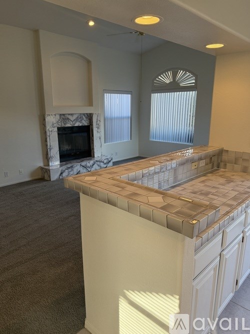 A kitchen with a marble fireplace and a tiled backsplash.