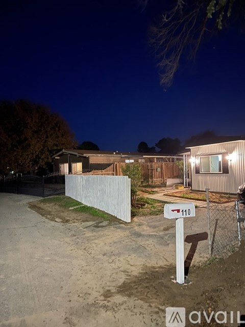A house numbered 110 is lit up at night.