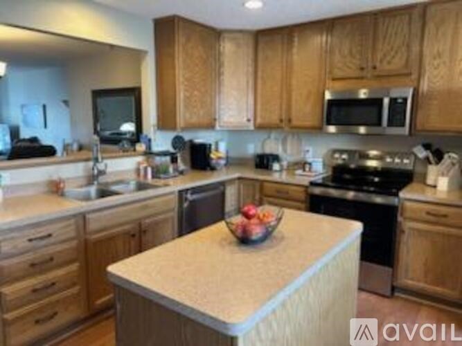A kitchen with wooden cabinets and a granite countertop.
