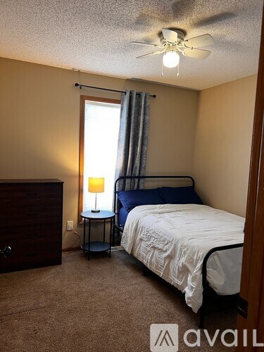 A living room with a couch, chair, and television.