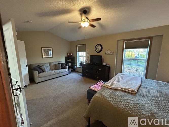 A bedroom with a bed, dresser, and couch in a house.